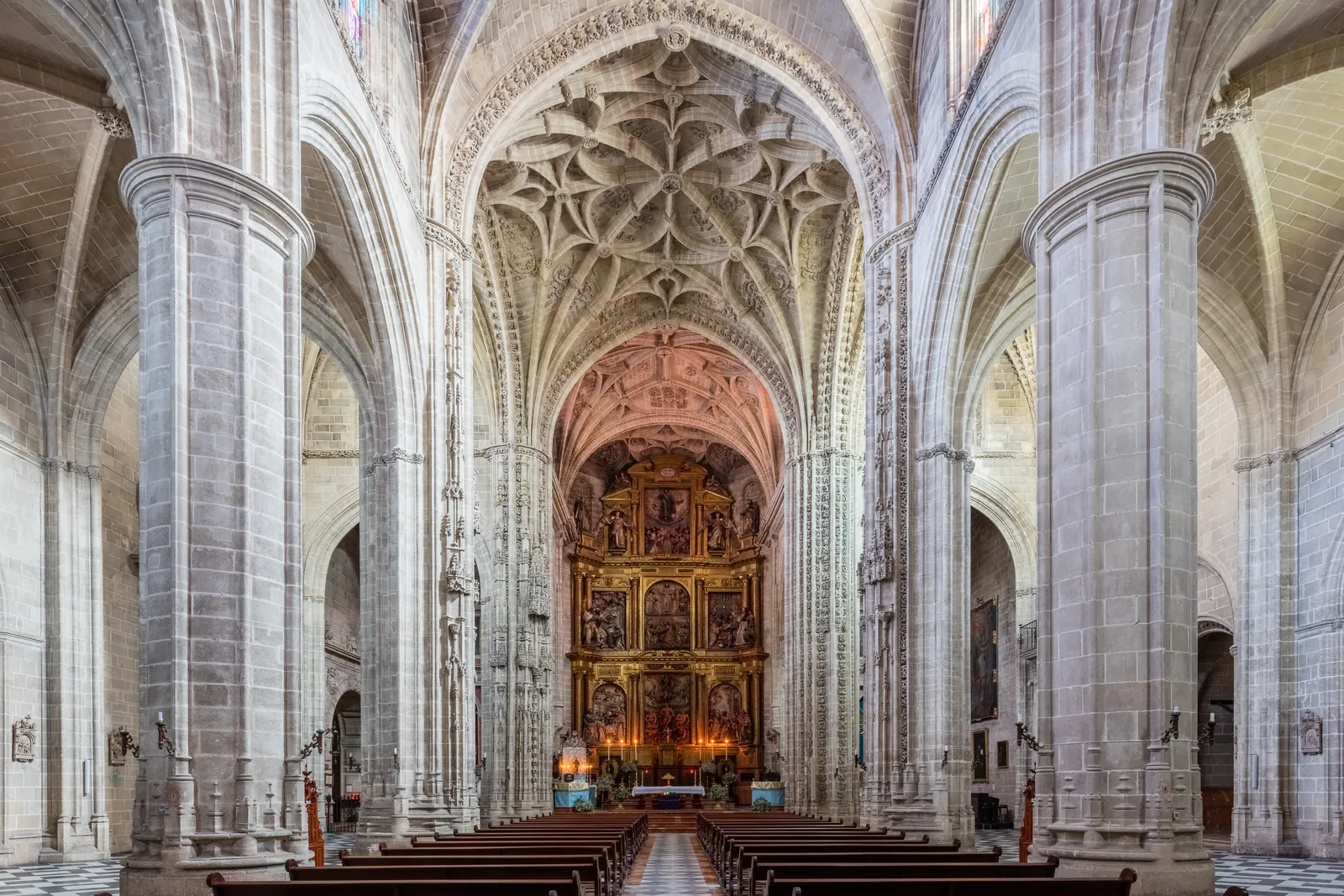 The Gothic nave of the church of San Miguel in Jerez, with ribbed vaults, tall pale columns and a gilded altarpiece at the far end